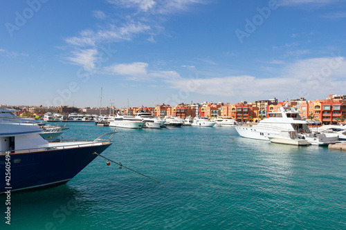 Panoramic view from the marina of Hurghada to moored yachts, boats, ships and the city's promenade with shops, cafes and a pedestrian zone for walking in the background