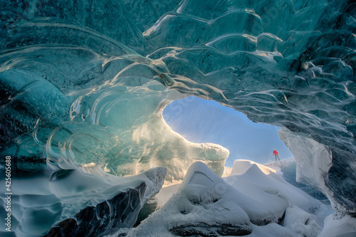 Fotografie, Obraz Man standing on edge of ice cave in Iceland