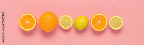 Citrus fruits orange and lemon in a row on a pastel pink background. Border. Top view, flat lay.