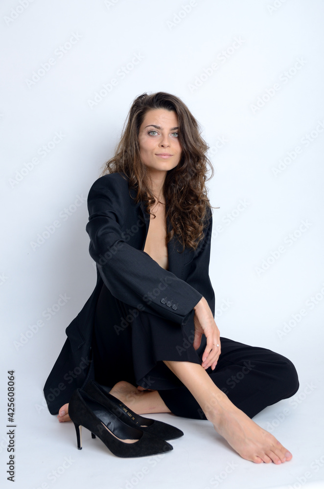 Young Polish woman in studio. Slim woman with dark hairs wearing black jacket and high heels. Young Polish woman in studio. Slim woman with dark hairs wearing black jacket and high heels.