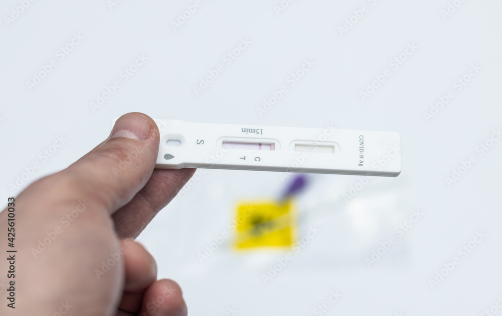 COVID 19, a man holding a negative antigen test in his hand, close-up. COVID 19, a man holding a negative antigen test in his hand, close-up.