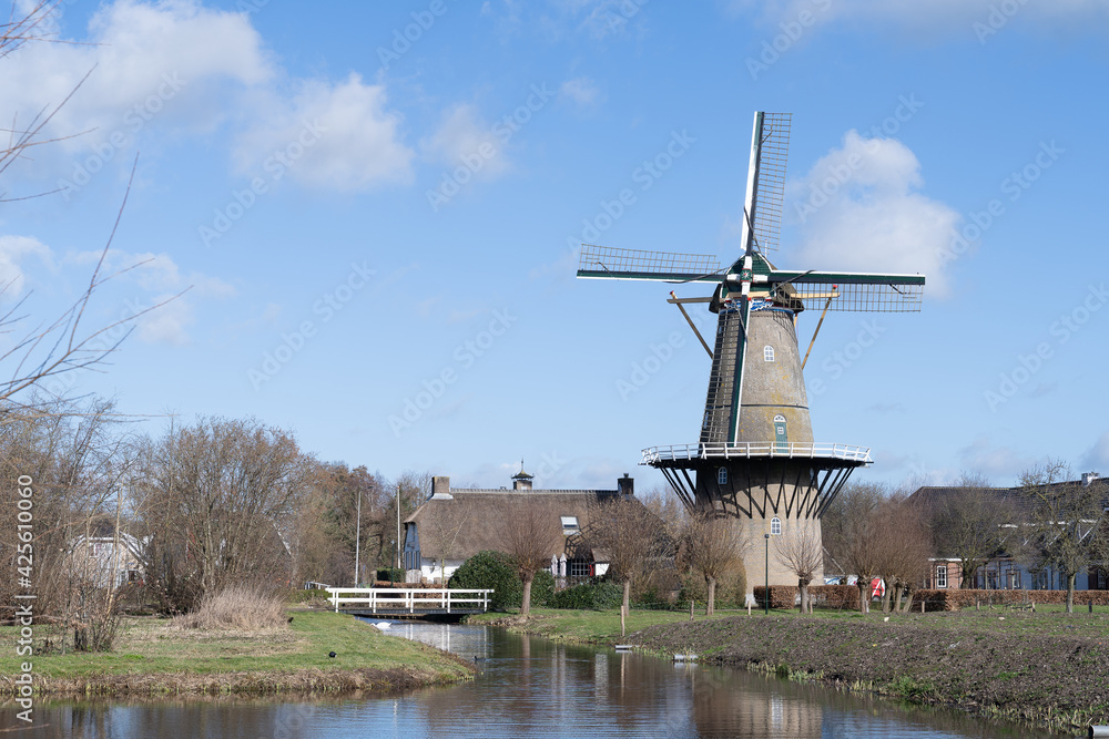 Bergambacht The Netherlands, 26 february 2021, Windmill Den Arend dating from 1869 in a farm landscape with water
