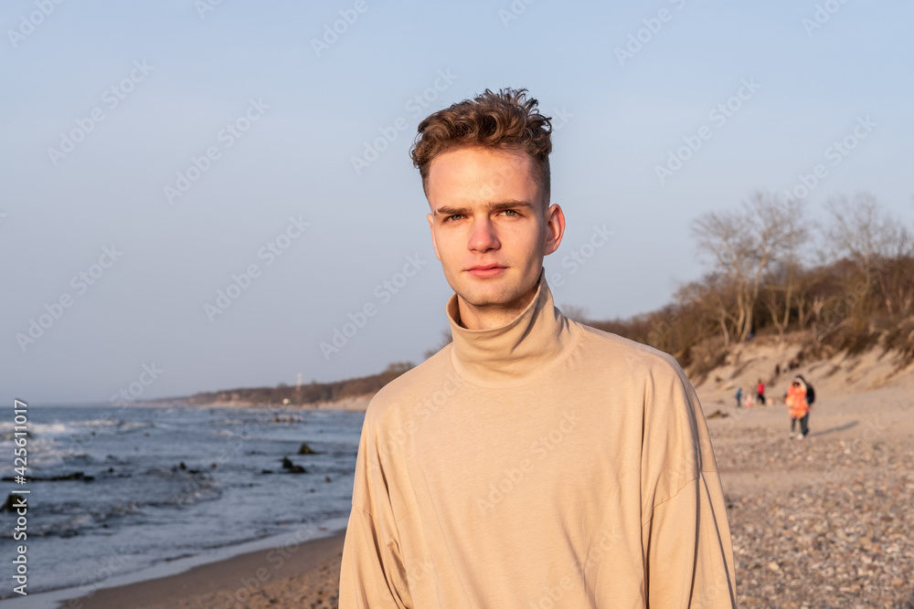 Portrait of a nice young guy, teenager on the background of the sea