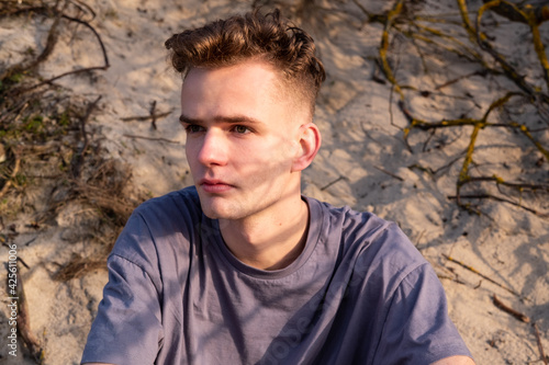 Portrait of a nice young guy on the background of nature