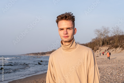 Portrait of a nice young guy, teenager on the background of the sea