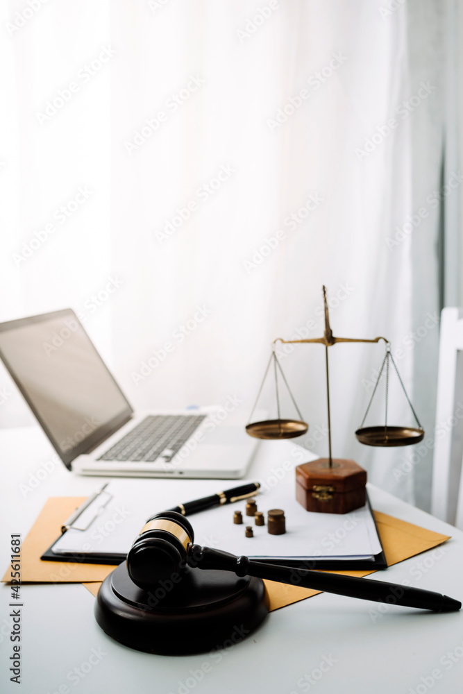 Business and lawyers discussing contract papers with brass scale on desk in office. Law, legal services, advice, justice and law concept picture with film grain effect Business and lawyers discussing contract papers with brass scale on desk in office. Law, legal services, advice, justice and law concept picture with film grain effect