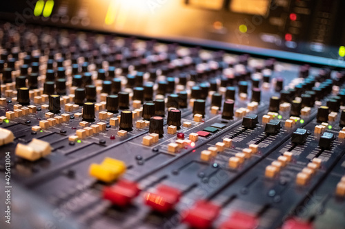 Recording with an audio mixing console turned on, using different faders, buttons and knobs