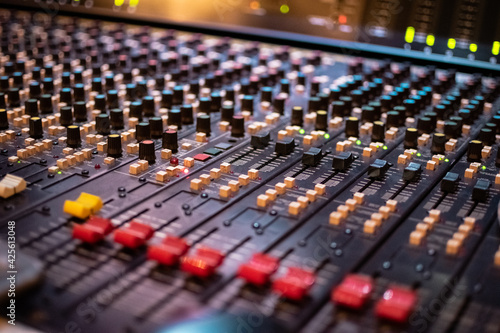 Recording with an audio mixing console turned on, using different faders, buttons and knobs