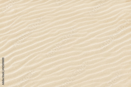 Abstract background. Diagonal sand stripes texture made by sea waves on beach.