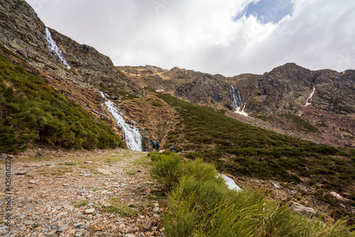 Estany de la Gola. On an early spring day. In the midst of the melting snow of winter, forming waterfalls on the tops of the mountains that end at the bottom of the valley.