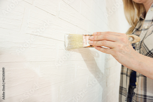 Happy woman painting interior wall of new house