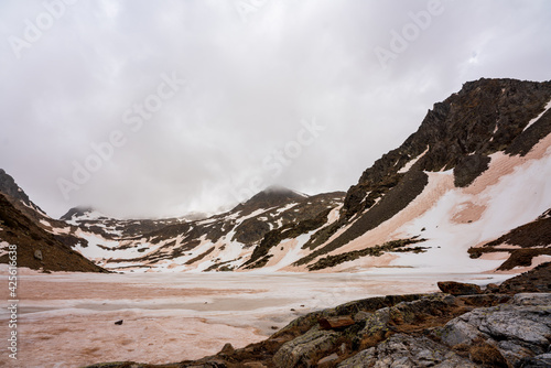 Estany de la Gola. On an early spring day. Completely frozen. Dirty mud snow from the suspended dust of the Sahara desert.