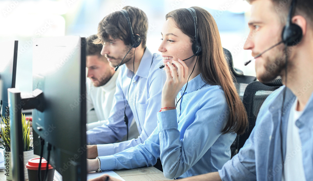 Attractive positive young businesspeople and colleagues in a call center office.