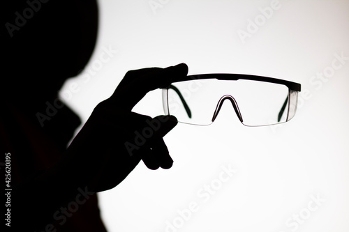Wallpaper Mural silhouette of builder with protective glasses in hand outstretched in camera on white isolated background, personal protective equipment concept Torontodigital.ca