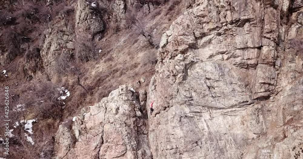 A group of people are engaged in rock climbing. High steep cliff. With the help of a rope, insurance and a partner, climbers climb to the top. Winter time of the year, sometimes there is snow. A group of people are engaged in rock climbing. High steep cliff. With the help of a rope, insurance and a partner, climbers climb to the top. Winter time of the year, sometimes there is snow.