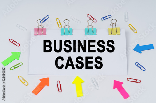 On the table there are paper clips and directional arrows, a sign that says - BUSINESS CASES