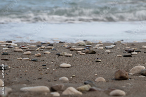 stones on the beach and blurred sea in the background