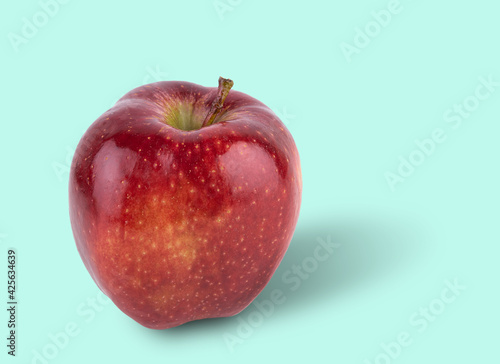 juicy red delicious apple on a light blue background. Front view