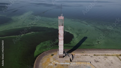 Aerial view of the old lighthouse by the green muddy flowered water photo