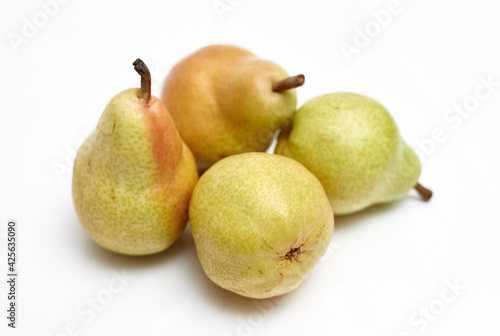 four ripe pears on a white background