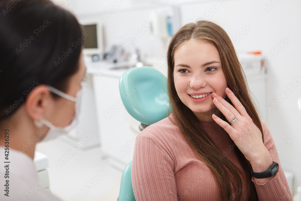 Charming young woman talking to her dentist Charming young woman talking to her dentist