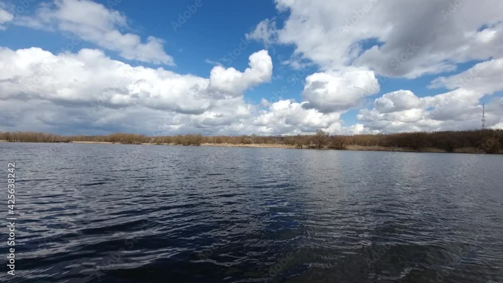 Running small waves on the river against the background of large clouds. Spring landscape Running small waves on the river against the background of large clouds. Spring landscape