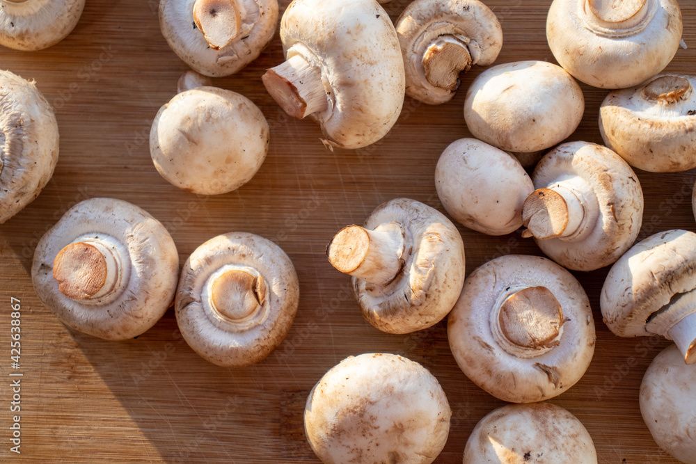 Fresh healthy brown mushrooms with very shallow depth of field. Mushrooms and champignons on the table. Mushrooms on the table top view Fresh healthy brown mushrooms with very shallow depth of field. Mushrooms and champignons on the table. Mushrooms on the table top view
