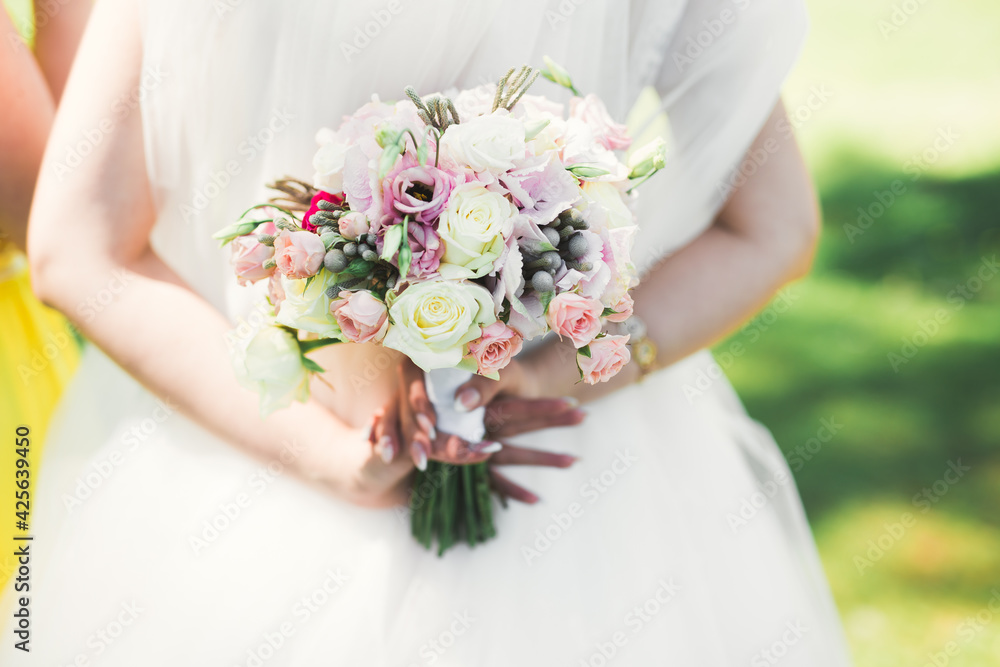 Bride holding big and beautiful wedding bouquet with flowers Bride holding big and beautiful wedding bouquet with flowers