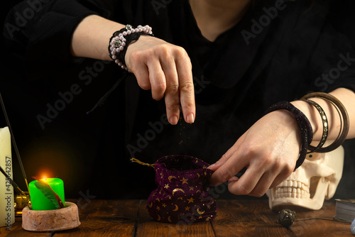 Fortuneteller's hands. The fortune teller opens a bag of herbs, a magic potion. Psychic readings and the concept of clairvoyance