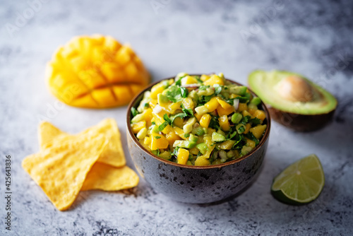 Mango Guacamole with corn chips and ingredients to prepare it
