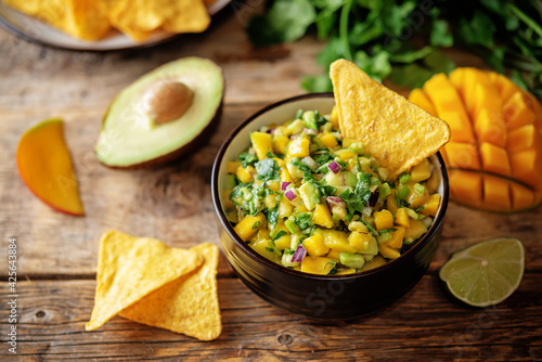 Mango Guacamole with corn chips and ingredients to prepare it