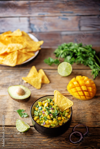 Mango Guacamole with corn chips and ingredients to prepare it