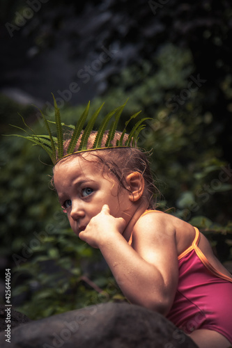 Lone scared child girl hiding in amazon forest