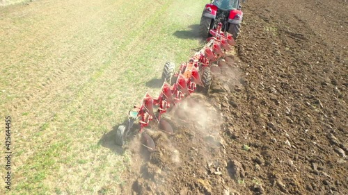 Aerial view to tractor with plough working on a field. Farmer use manure for organic growing.  Agriculture from above. Environmentally friendly farming.