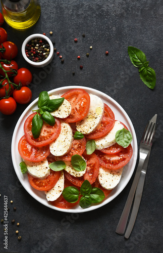 Caprese is a tomato and mozzarella appetizer. Traditional Italian salad on a concrete background with space for text.