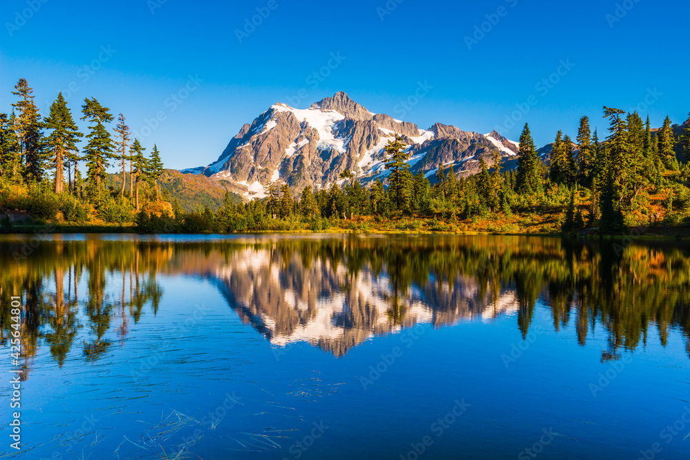 Mount Shuksan reflecting in Picture Lake on a clear blue sky fall evening
