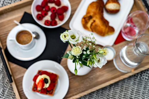 Breakfast in bed. Raspberries, coffee, cake, croissant. Cozy hotel.