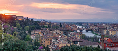 Panoramic view of Florence at sunset with in the background, the Basilica di Santo Spirito and its spire, the Church of San Frediano in Cestello and Ponte Vecchio.