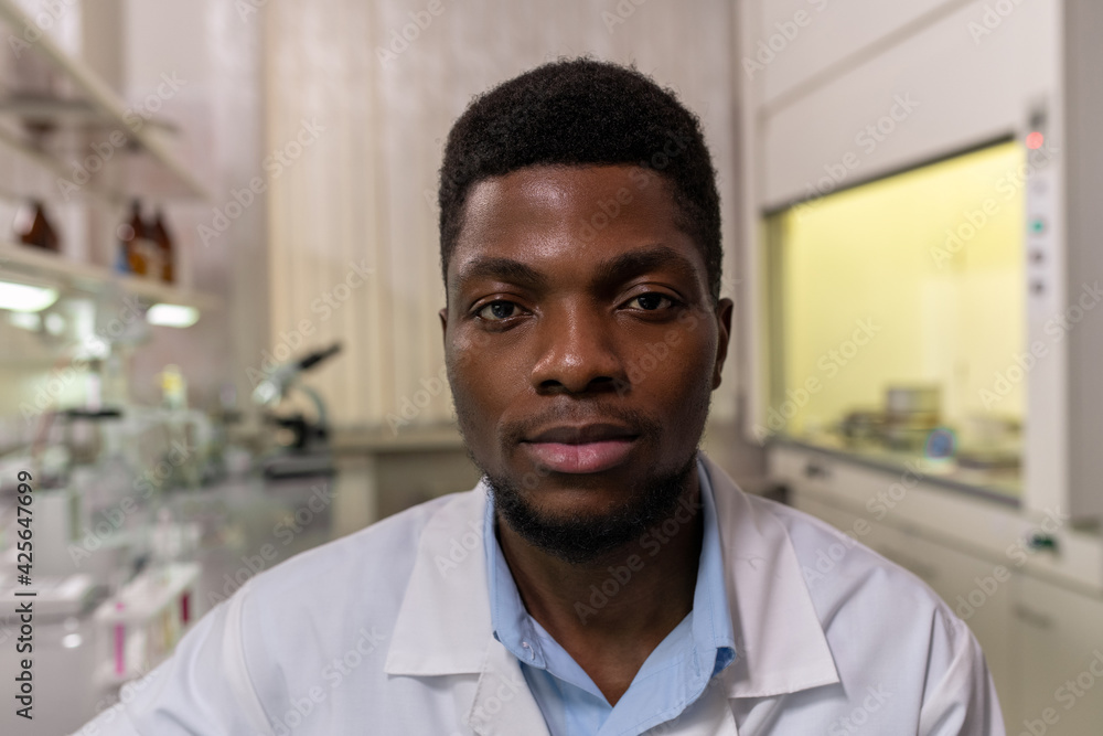 Portrait of African young scientist looking at camera while working in the laboratory Portrait of African young scientist looking at camera while working in the laboratory