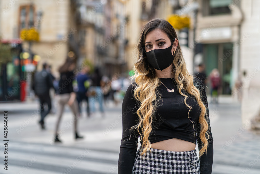 Obraz premium woman with a mask on her face, due to the coronavirus pandemic. Air, covid-19, 2019-ncov prevention