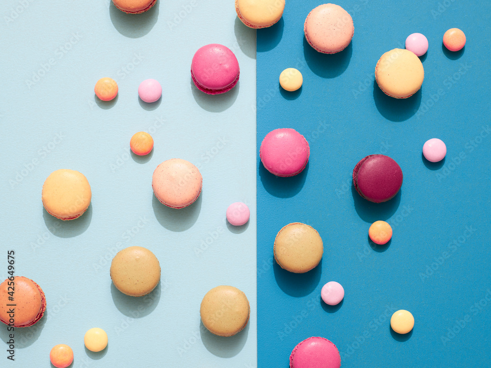 Delicious macarons with candies on a vibrant colorful background with copyspace