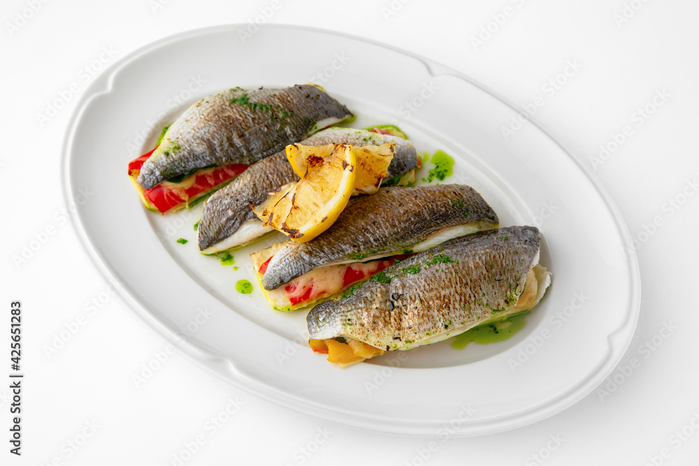 Dorada stuffed with vegetables, baked in the oven with cheese. Banquet festive dishes. Gourmet restaurant menu. White background. Dorada stuffed with vegetables, baked in the oven with cheese. Banquet festive dishes. Gourmet restaurant menu. White background.