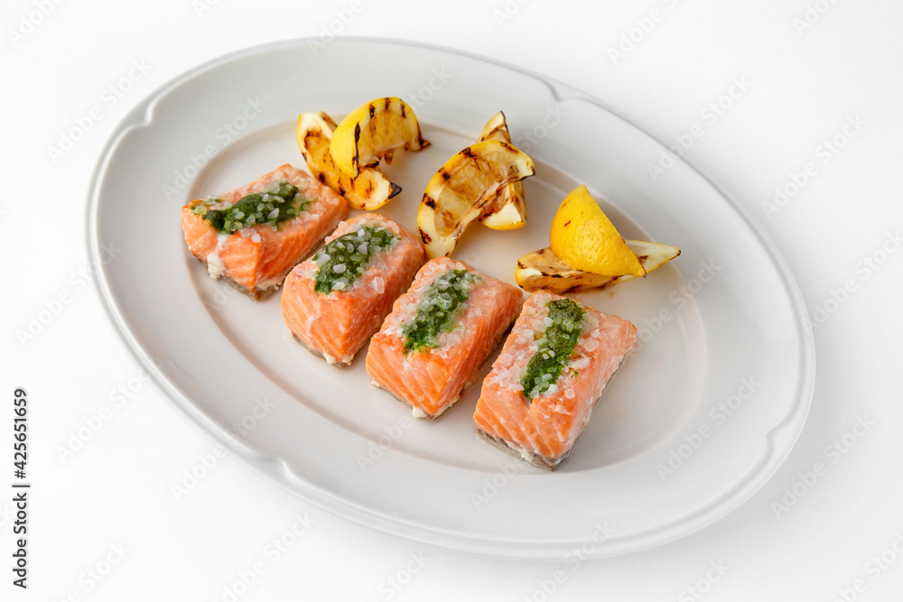 Large pieces of fillet baked with salmon cheese and sauce. Banquet festive dishes. Gourmet restaurant menu. White background. Large pieces of fillet baked with salmon cheese and sauce. Banquet festive dishes. Gourmet restaurant menu. White background.