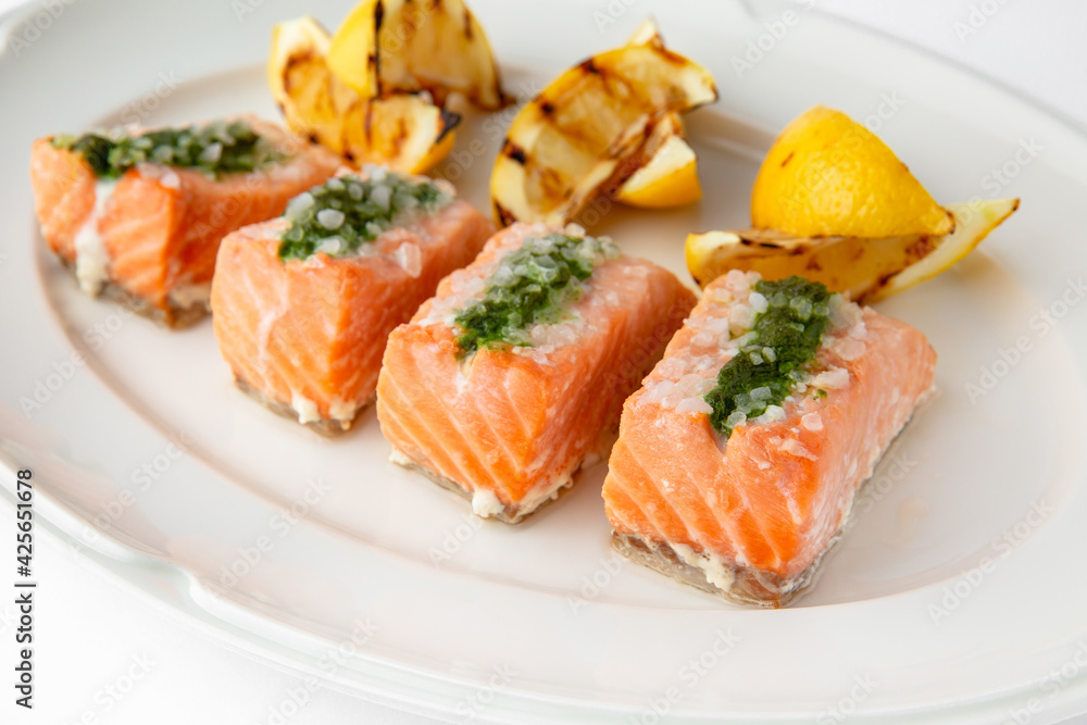 Large pieces of fillet baked with salmon cheese and sauce. Banquet festive dishes. Gourmet restaurant menu. White background. Large pieces of fillet baked with salmon cheese and sauce. Banquet festive dishes. Gourmet restaurant menu. White background.