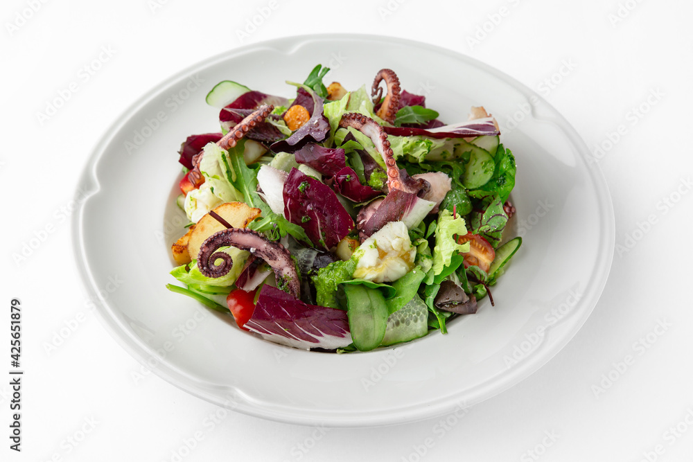 Salad with octopus, vegetables and herbs. Banquet festive dishes. Gourmet restaurant menu. White background.