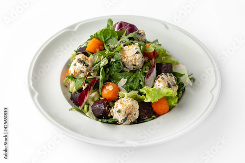 Vegetarian salad with balls of tofu and nuts, roasted beets, carrots and greens. Banquet festive dishes. Gourmet restaurant menu. White background.