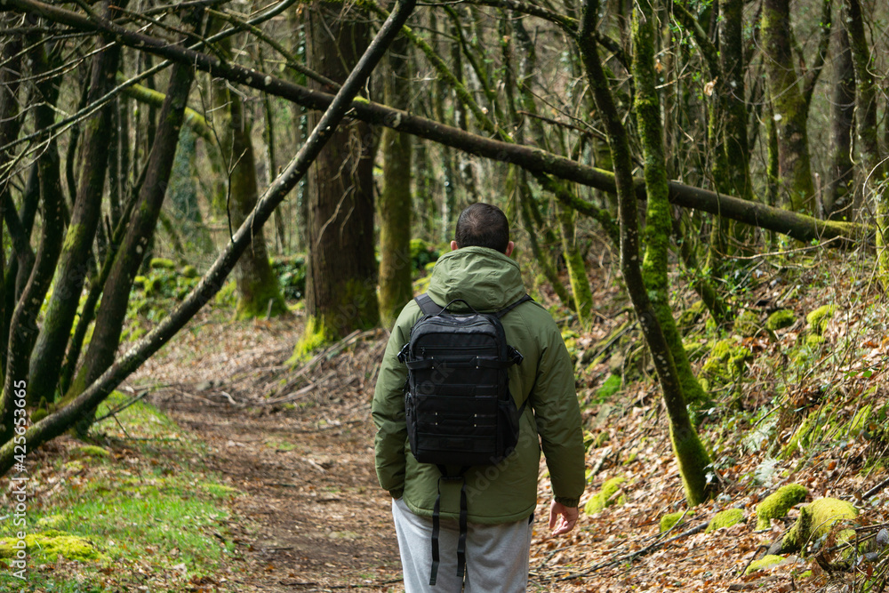 Happy man walking on a path with a backpack. Lifestyle concept, hike, outdoors.