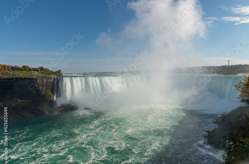 Horseshoe falls on Niagara river with a tall cloud of water splashes