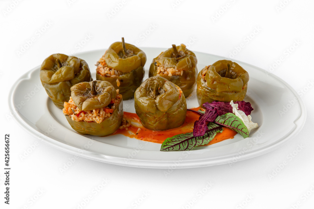 Sweet peppers stuffed with rice, vegetables and meat, baked in the oven. Banquet festive dishes. Gourmet restaurant menu. White background. Sweet peppers stuffed with rice, vegetables and meat, baked in the oven. Banquet festive dishes. Gourmet restaurant menu. White background.