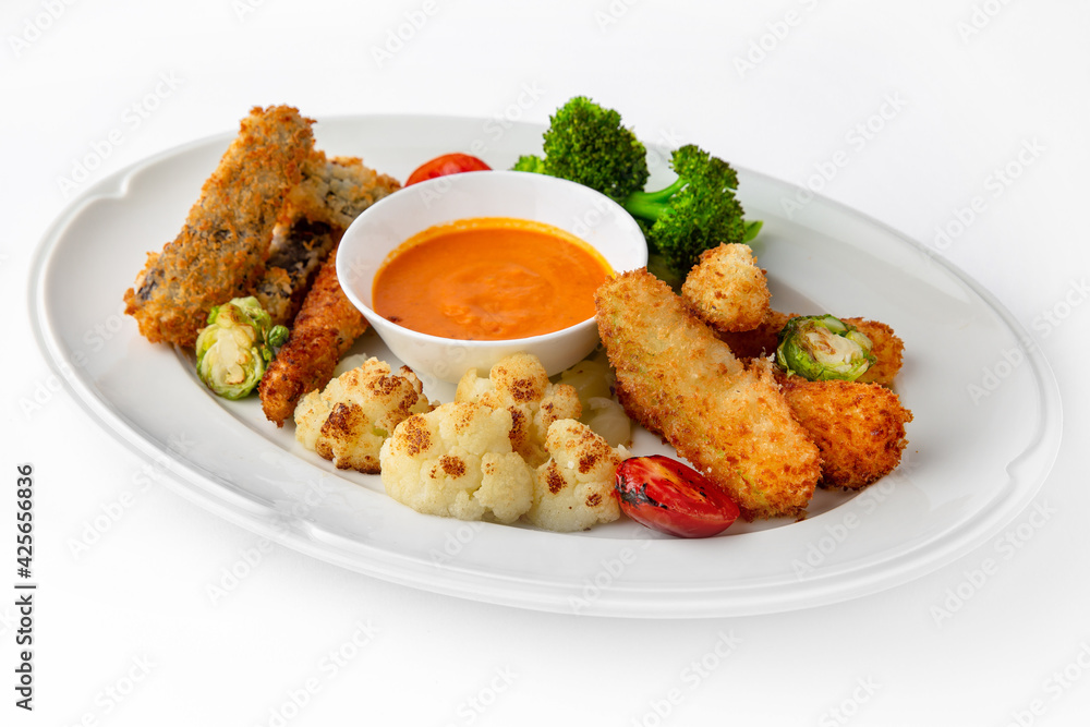 Fish fillets, chicken in batter with vegetables. Banquet festive dishes. Gourmet restaurant menu. White background. Fish fillets, chicken in batter with vegetables. Banquet festive dishes. Gourmet restaurant menu. White background.